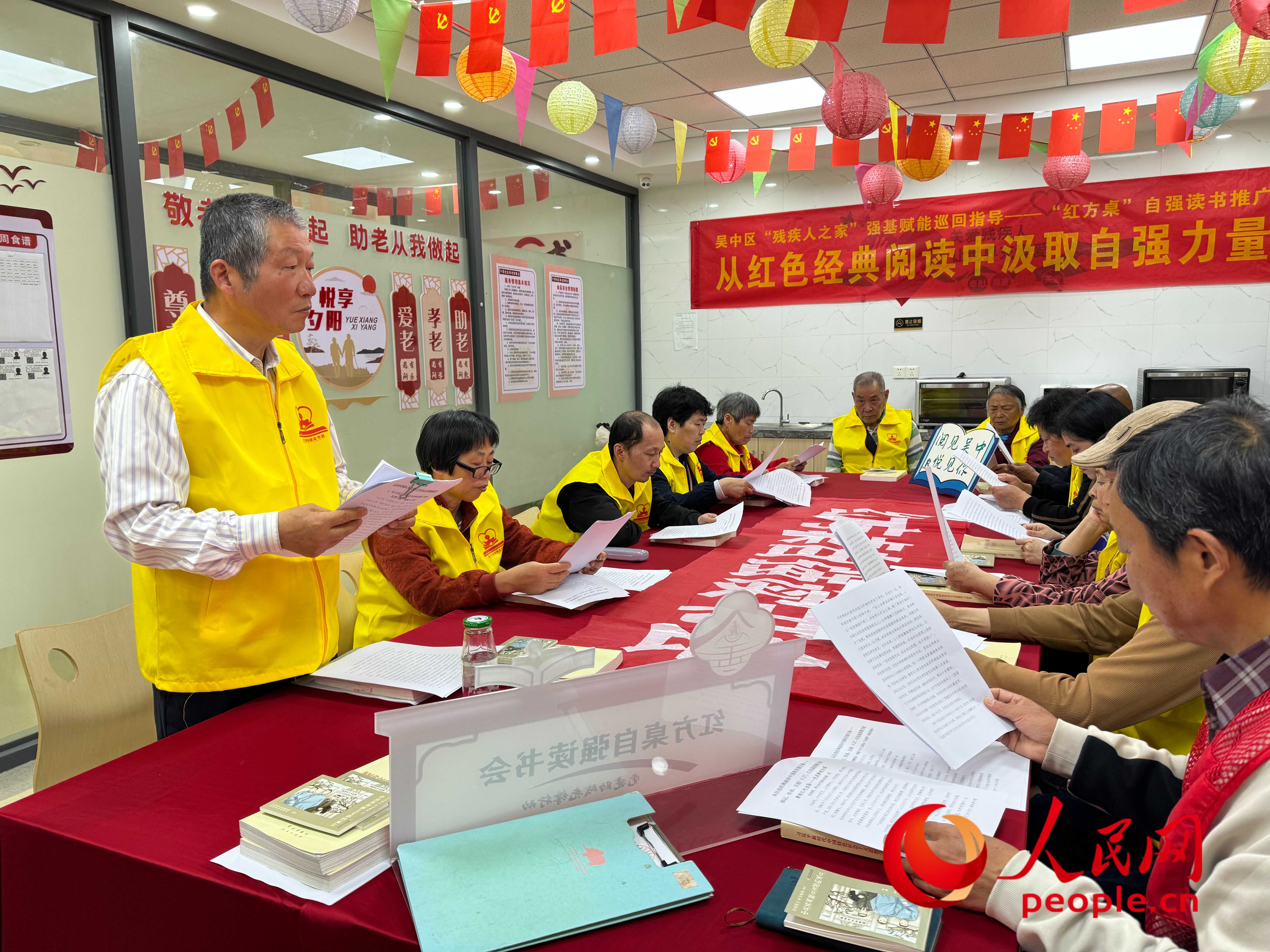 周凤生（左一）带着残疾人书友一起阅读。人民网 周静圆摄